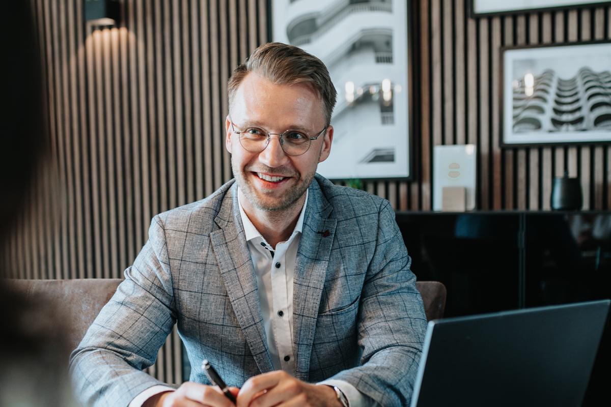 Thomas Hacker sitzt am Schreibtisch und unterschreibt Unterlagen